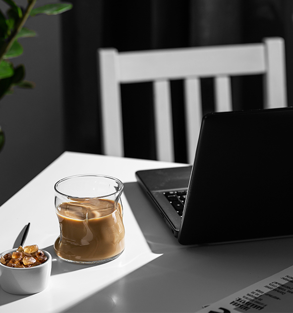 Schreibtisch mit Laptop und Kaffee